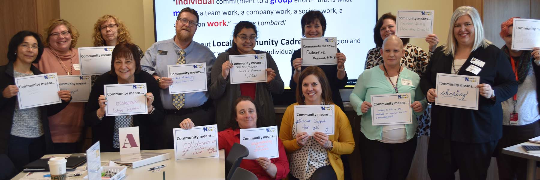 IIACC members holding signs stating what community means for them